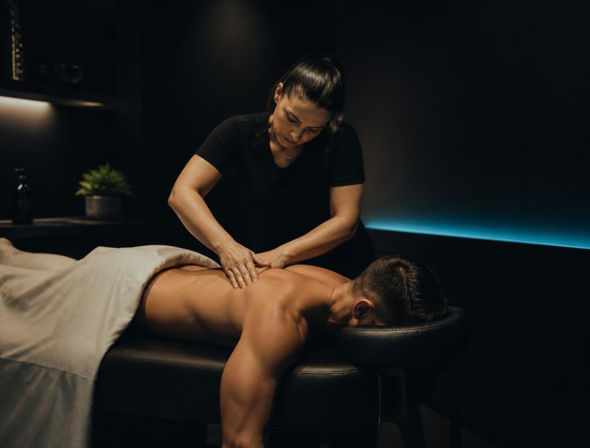 Licensed massage therapist working on an athlete's shoulder at District Flex